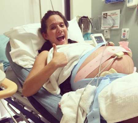 Woman lying in hospital bed pregnant with triplets