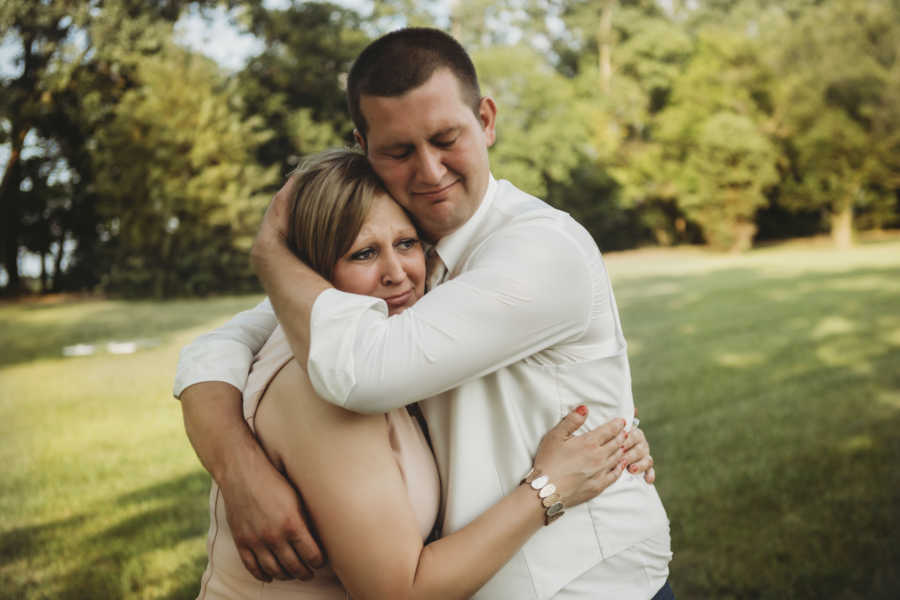 Groom and mother with breast cancer cry as they hold each other outside 