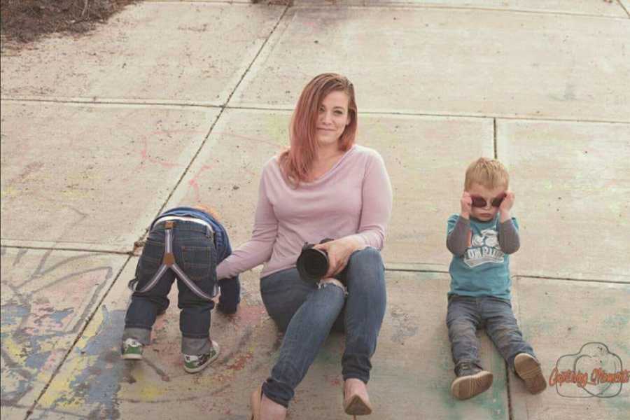 Mother whose children caused her to have panic attack sits on pavement with two toddler boys