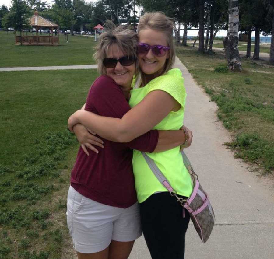 Daughter who brought her wedding to sick dad stands on sidewalk hugging mother