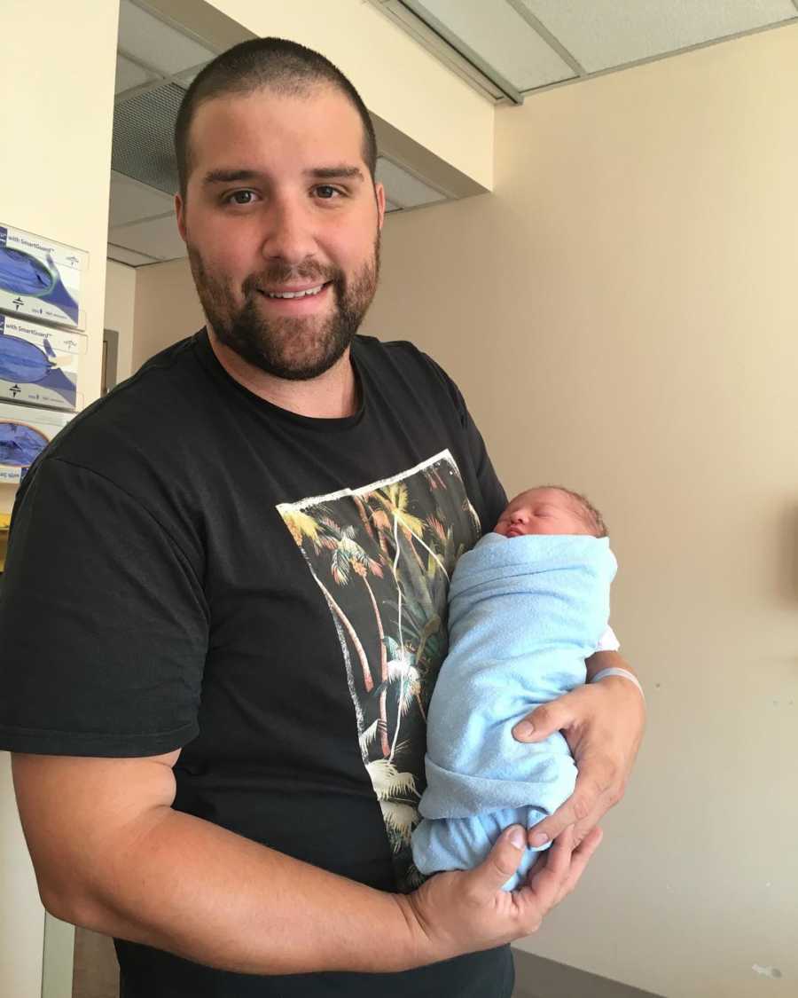 New dad holds his newborn son in the hospital