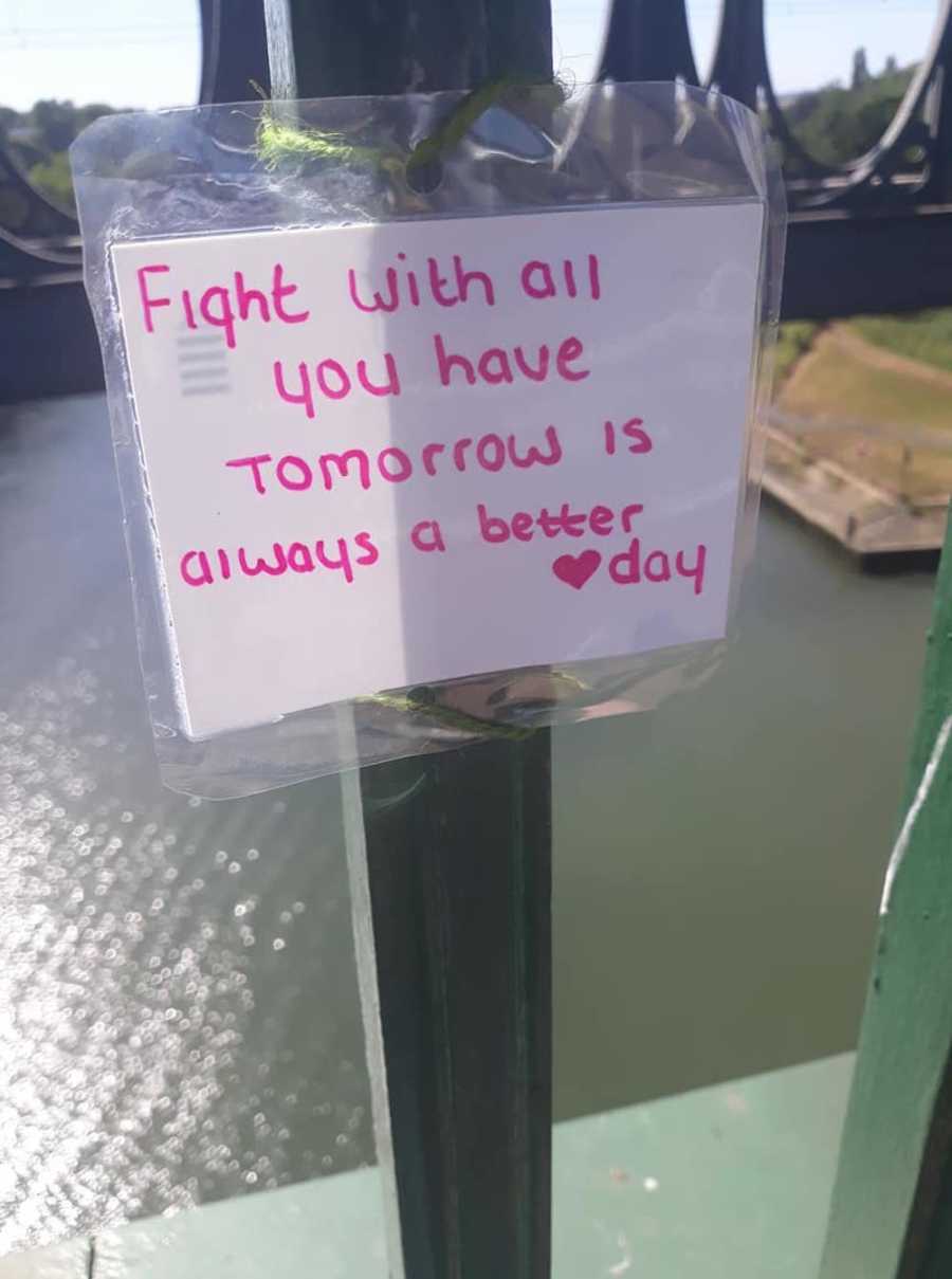 Woman attaches note to bridge that says "Fight with all you have tomorrow is a better day"