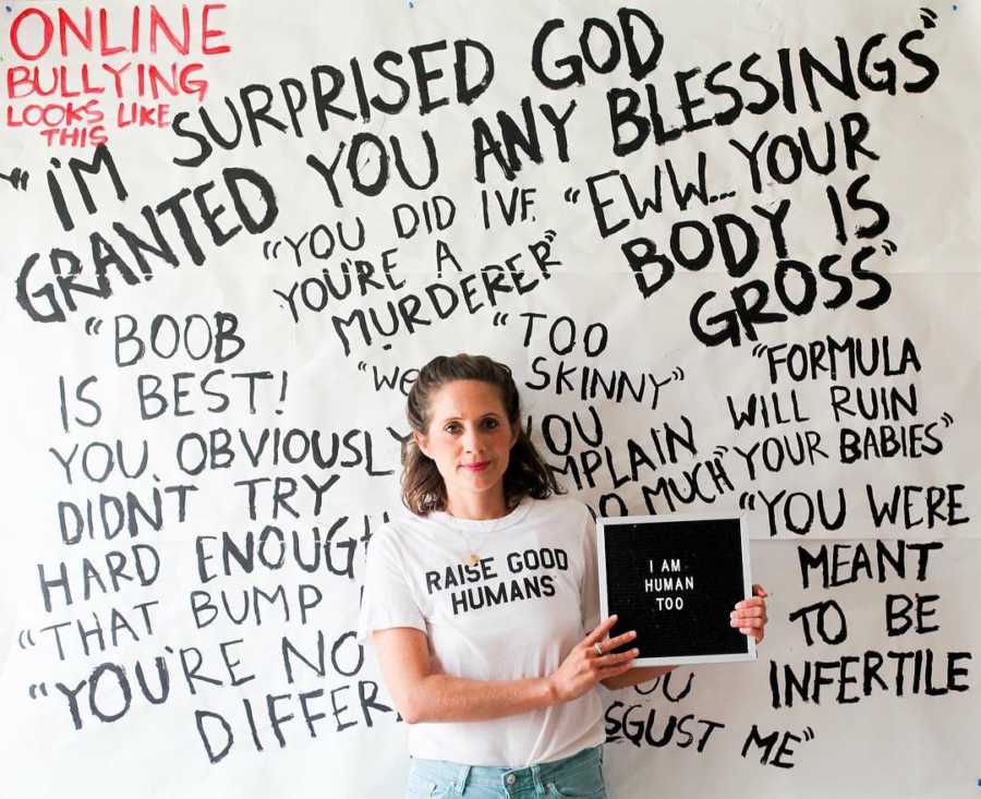 Mother who is also a blogger stands in front of wall of all the hateful words people have said to her