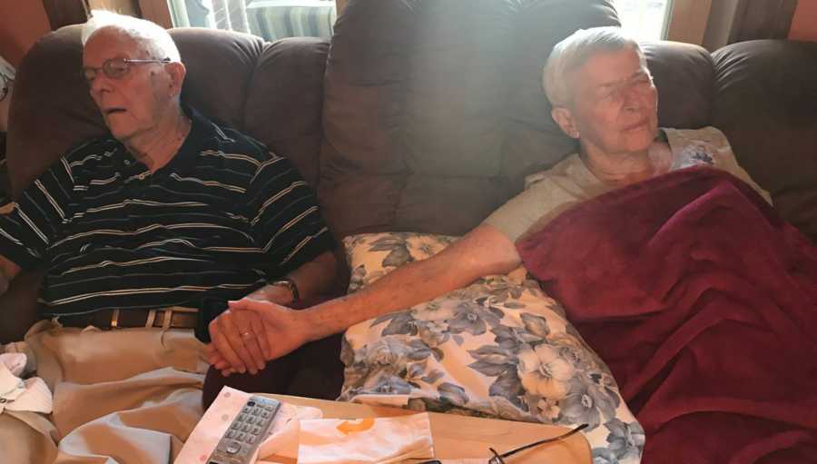 Woman with dementia asleep on couch holding husband's hand who is asleep next to her