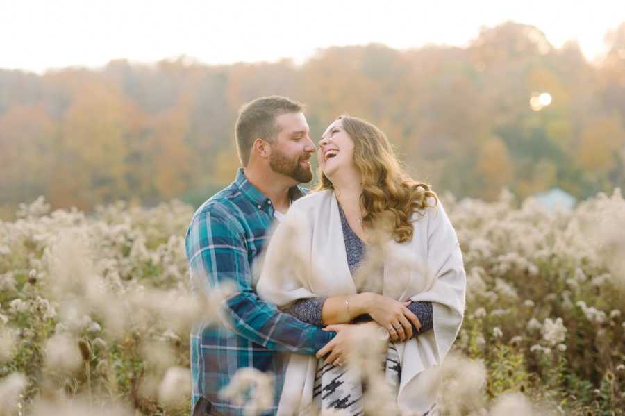 Woman laughs at her husband during candid moment during a photoshoot in a cotton field