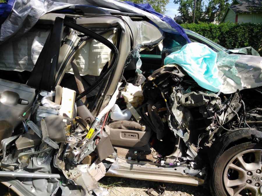 Woman takes a photo of her destroyed car after a near-fatal car accident