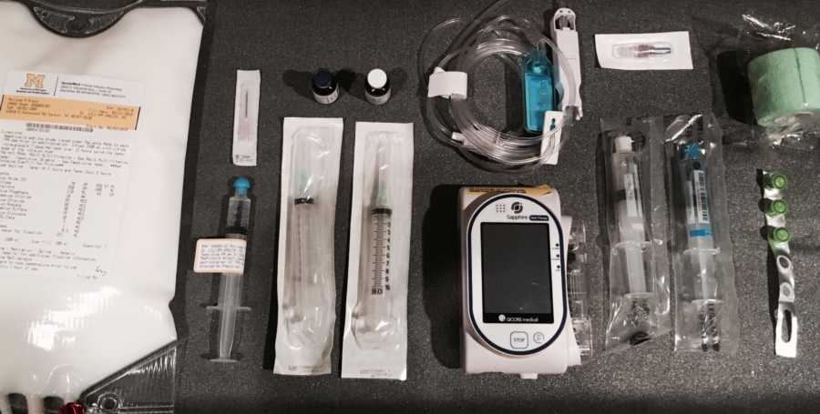 Medications, needles, and devices lying on counter to help treat woman with pandysautonomia