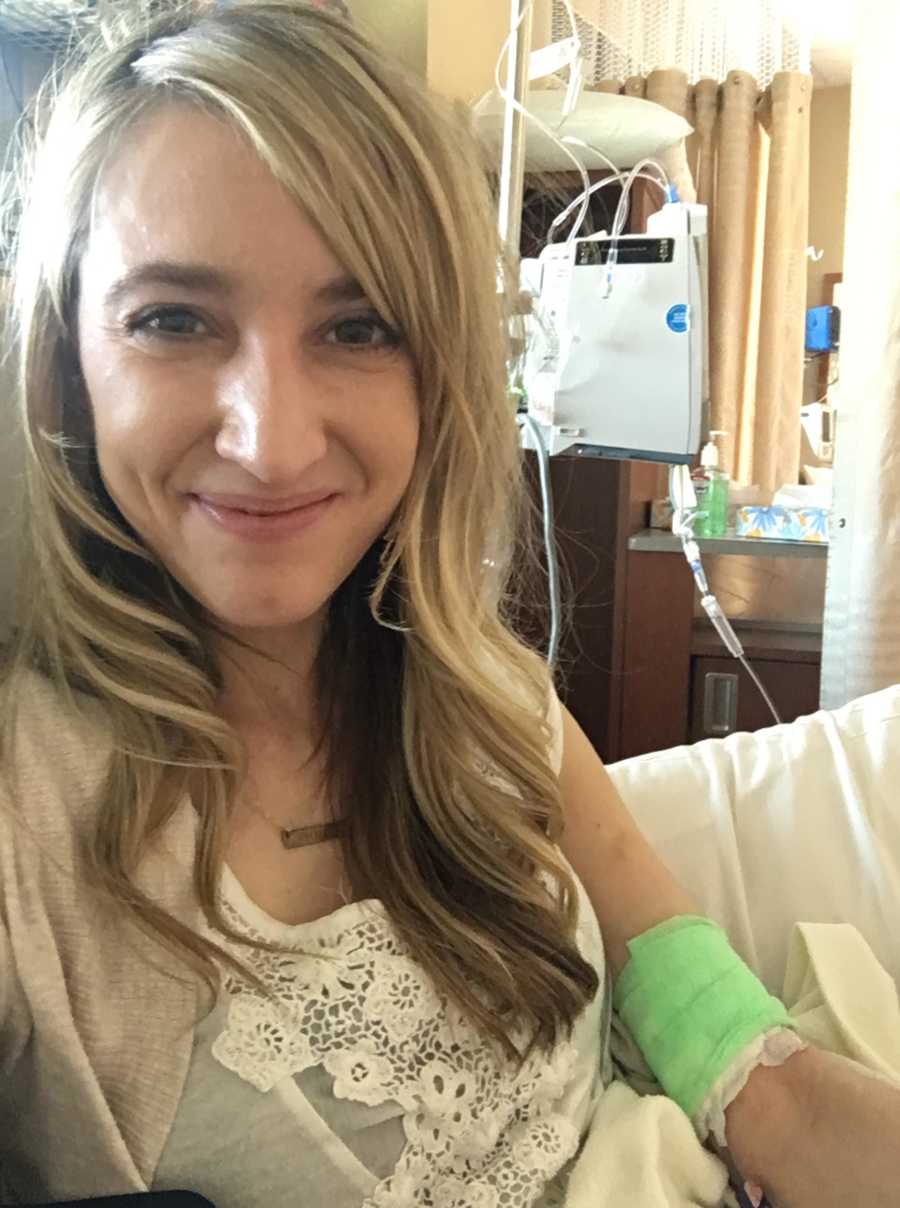 Woman with pandysautonomia smiles in selfie in hospital with bandage wrapped around her arm