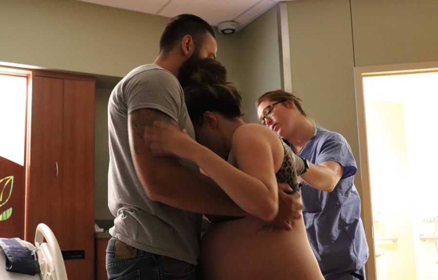 Husband holds wife up while she stands during contractions