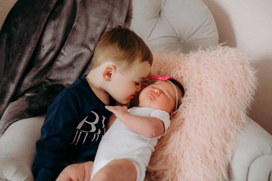 Big brother holds his new baby sister for the first time in her nursery