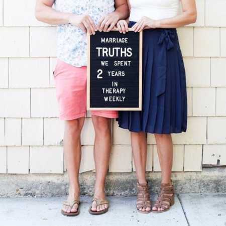 Married couple holds sign saying, "marriage truths we spent 2 years in therapy weekly"