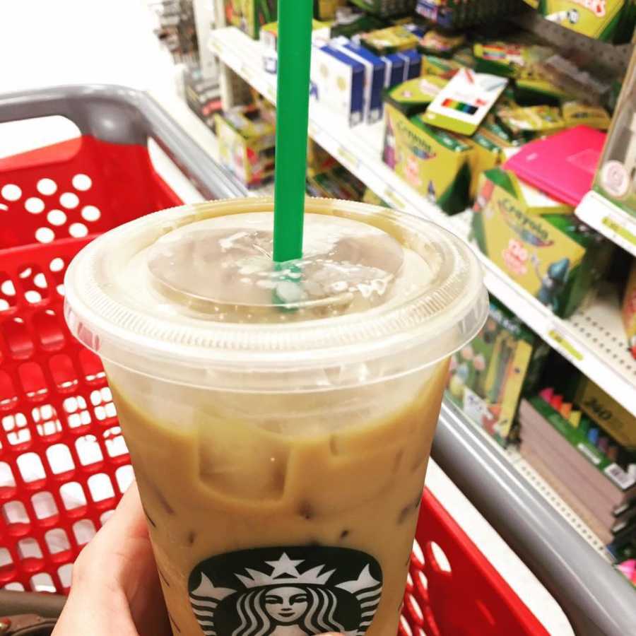 Iced Starbucks drink belonging to mother who is doing first school supply shopping for child at Target