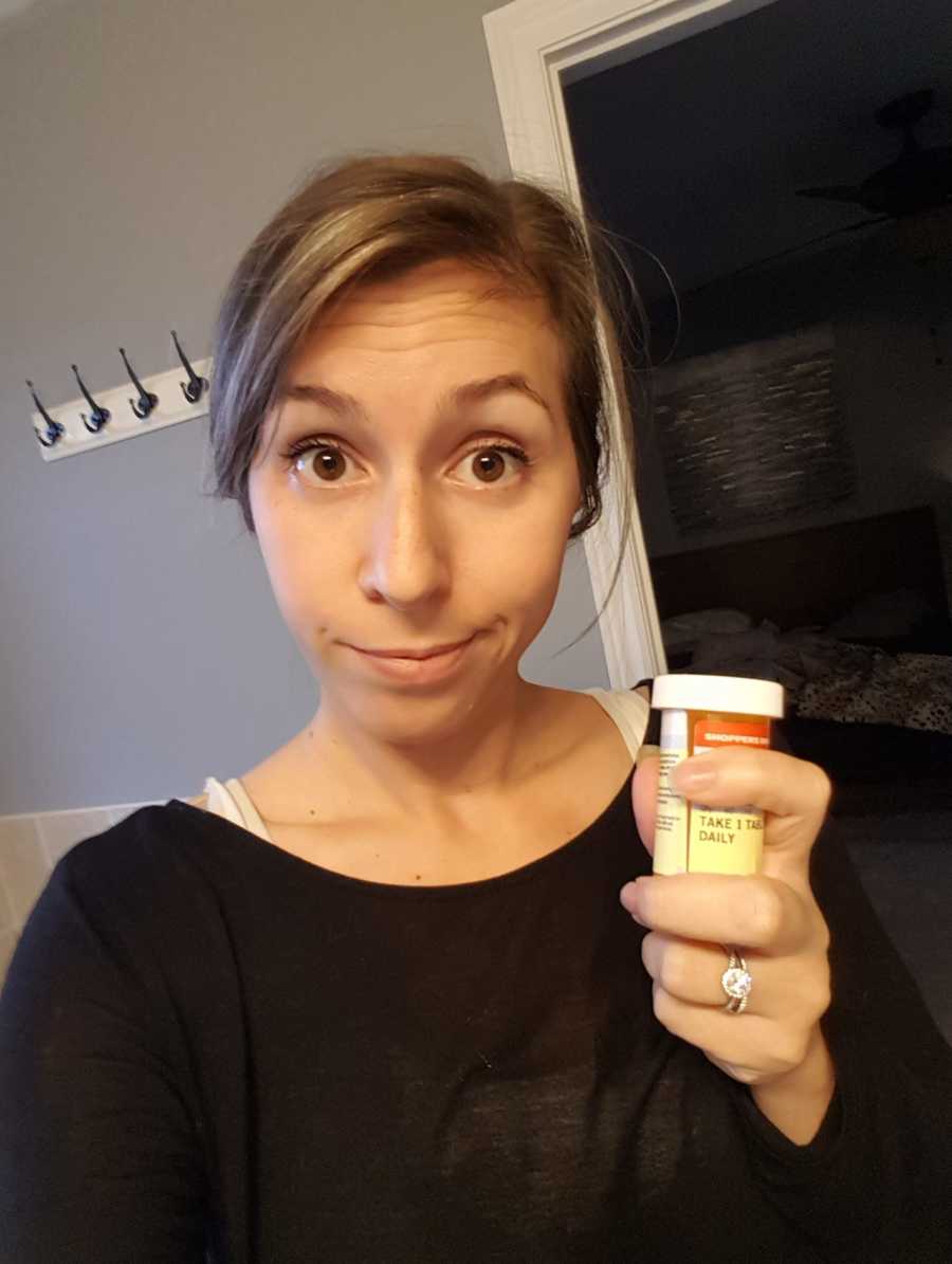 Mother who suffers with postpartum depression holds pill bottle that saved her life in selfie