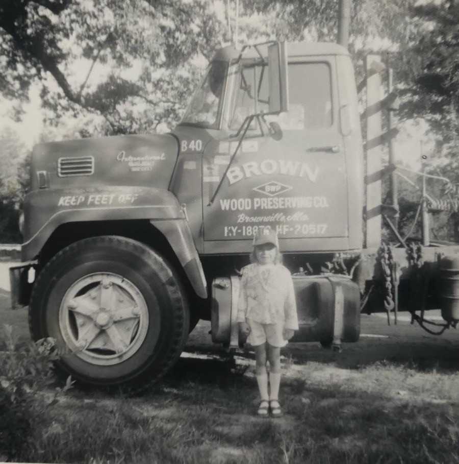 Woman whose daughter surprised her with tattoo in her father's handwriting as a little girl standing beside truck