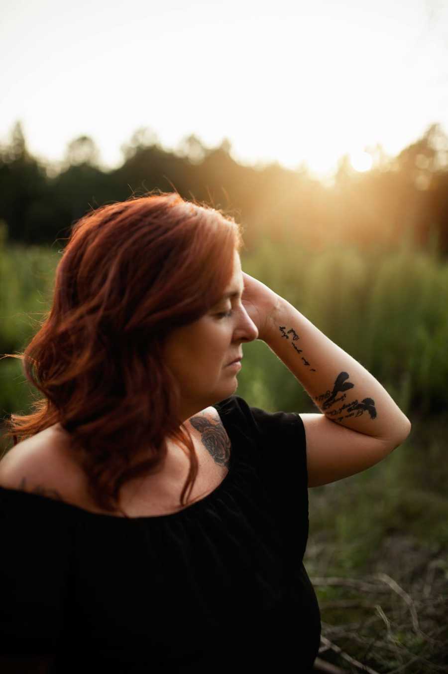 Woman holding up arm with tattoo on it saying, "I love you shug, dad" in her late father's handwriting