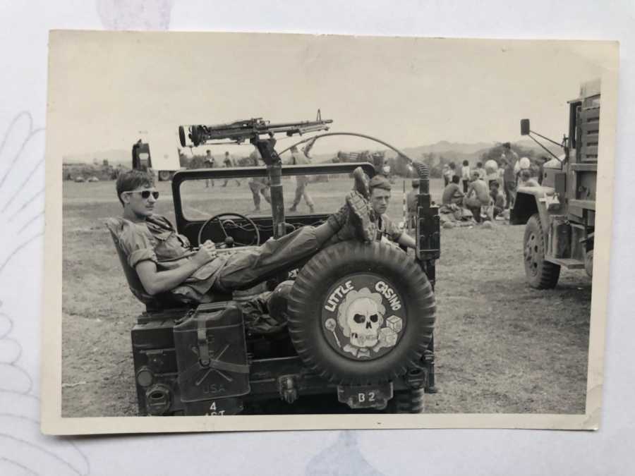 Man sitting in army vehicle who has since passed whose daughter got a tattoo of his handwriting