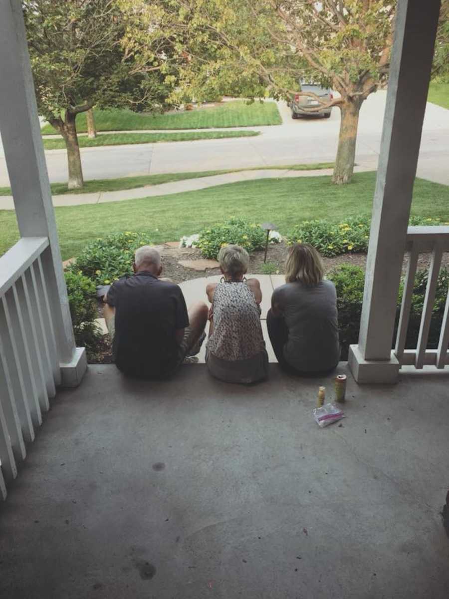 Woman who is reminded that her parents struggled the same way she did sits on front steps of house with them 