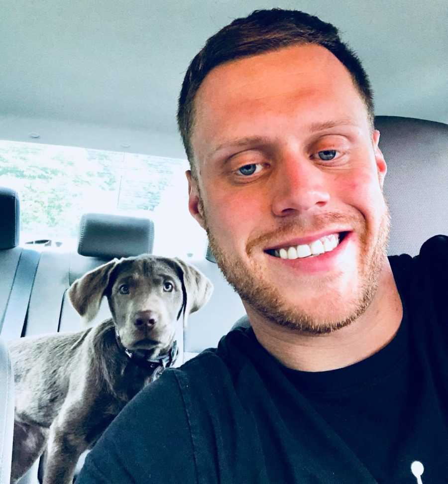 Man who got clean smiles in selfie in car with dog in back seat