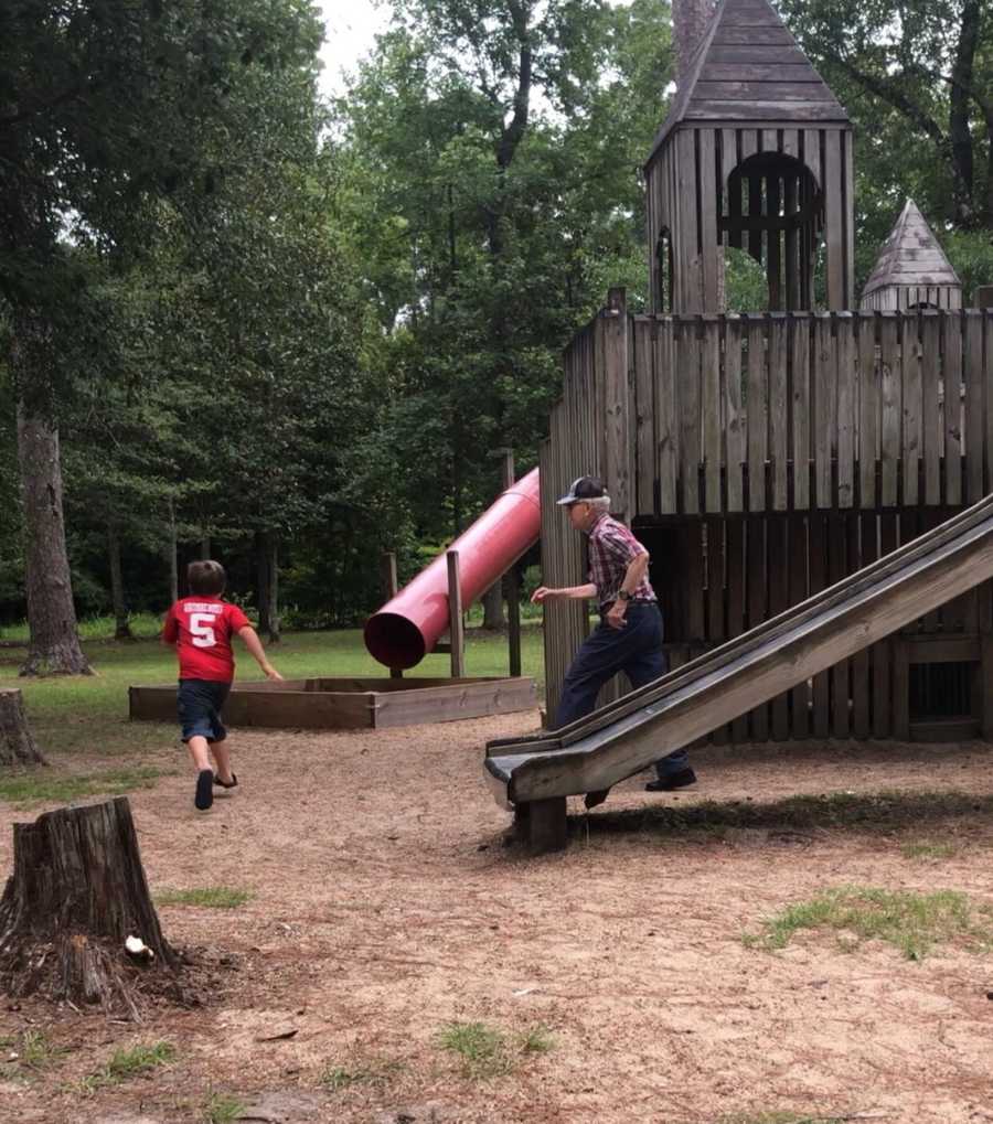 Grandfather chasing grandson around on playground