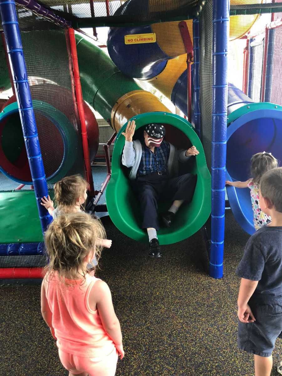 Elderly man slides down McDonald's play place slide while his grandchildren and other kids wait for him