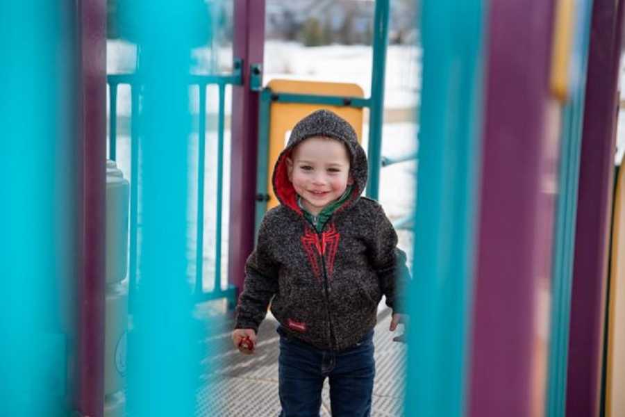 Child whose mother had panic attack smiles on play structure 