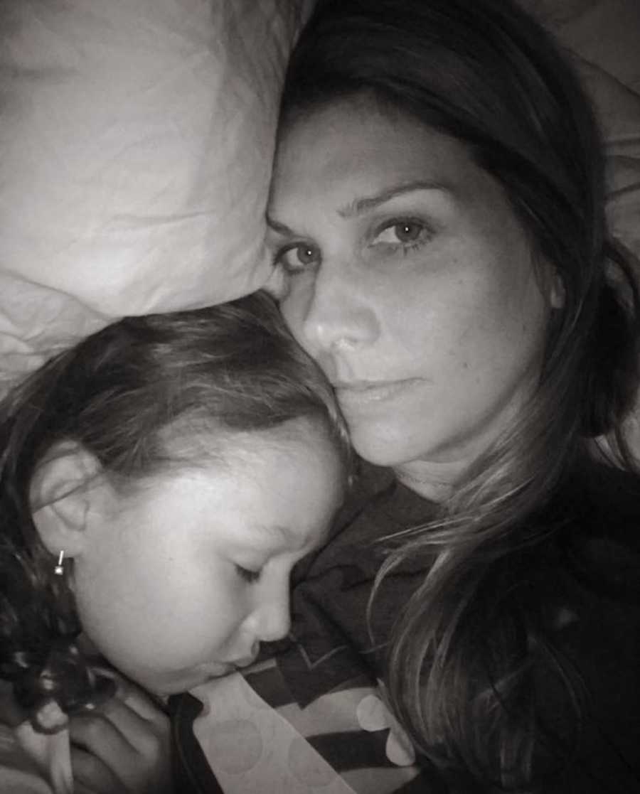 Woman lying next to niece whose mother has caner in bed in selfie