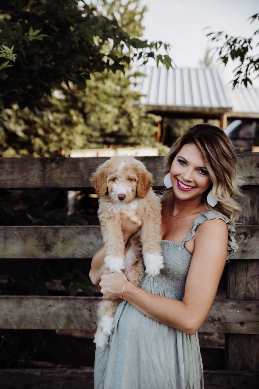 Recently single dog mom smiles while holding puppy