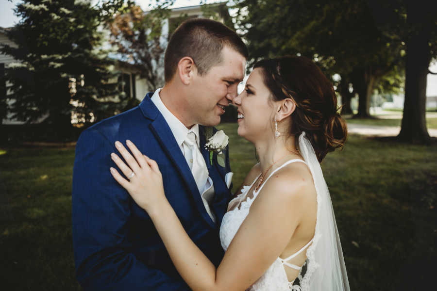 Bride and groom stand holding each other looking into each others eyes