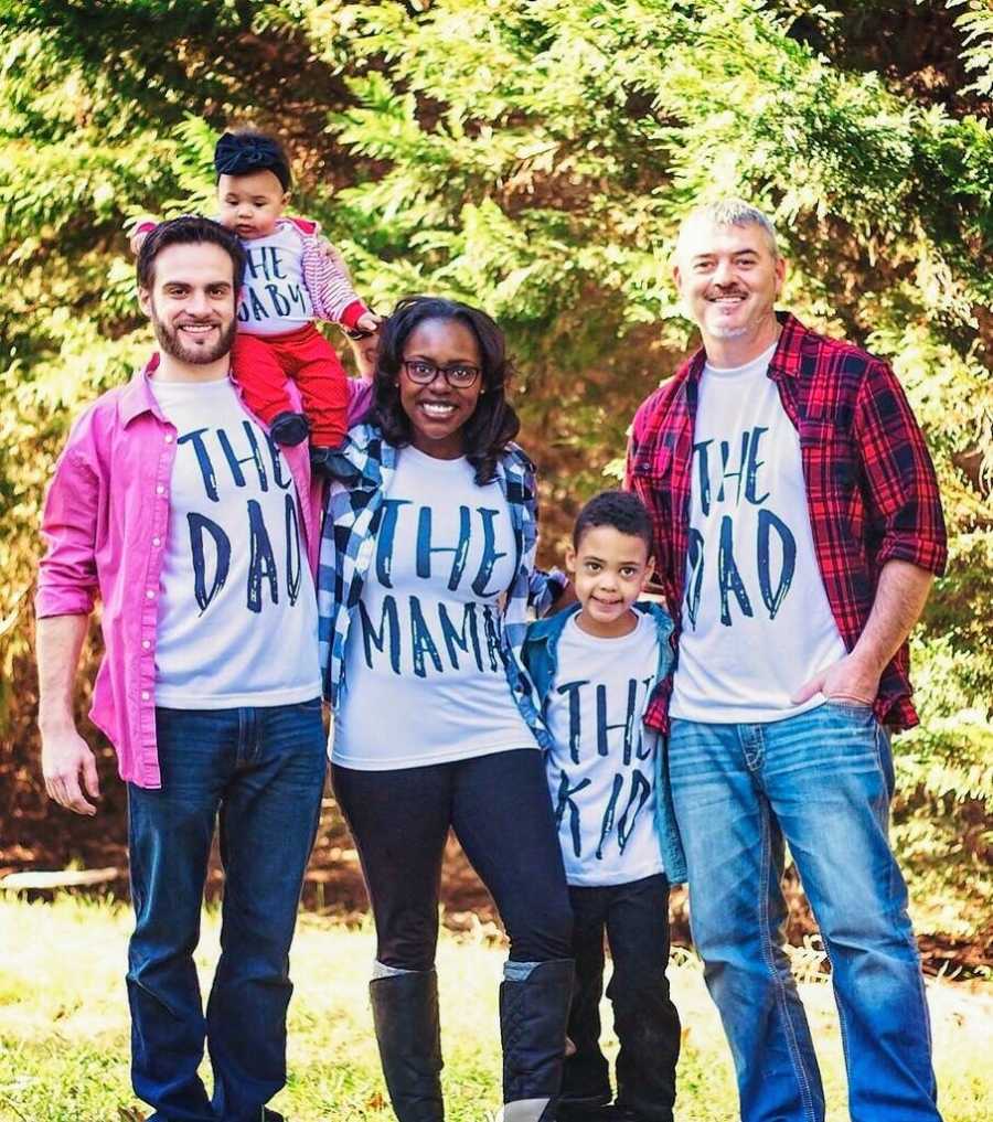 Woman stands smiling with her husband and ex husband along with two kids