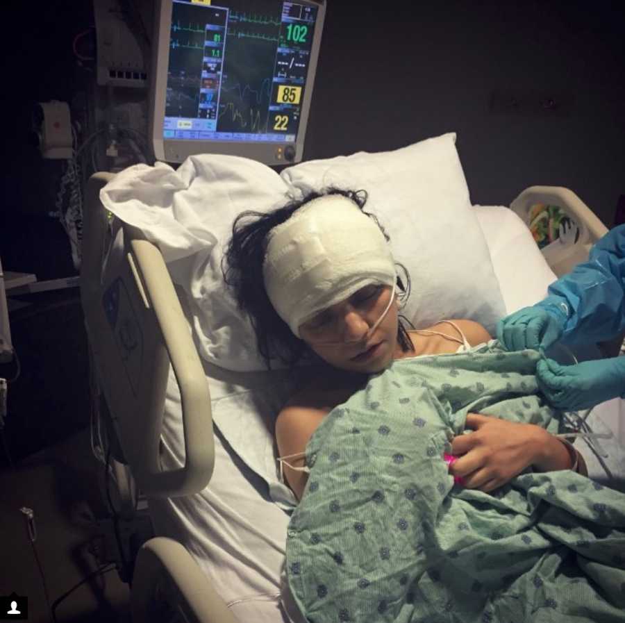 Woman with Chiari Malformation lays in hospital bed with bandages on head after brain surgery