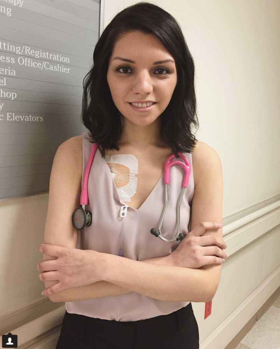 Woman with Chiari Malformation who is studying to be a doctor stands smiling with arms crossed 