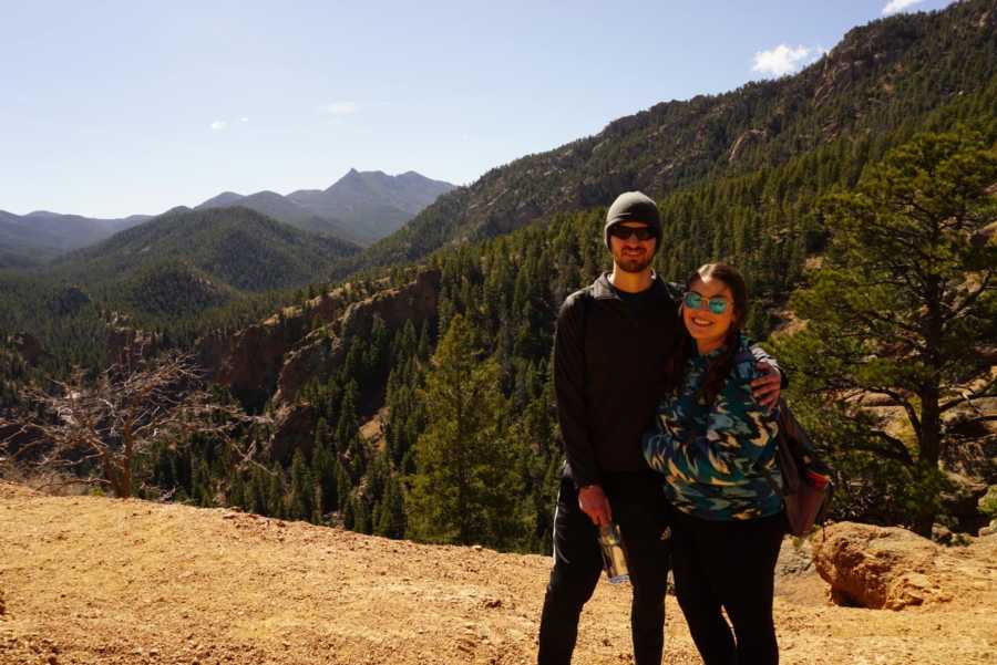 Woman who did intermittent fasting standing on top of mountain with boyfriend