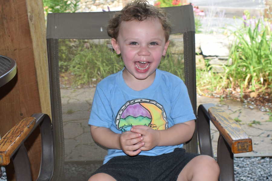 Child who almost drown smiles in chair outside