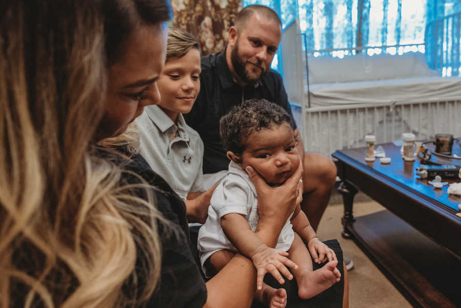 Mom squeezes her newborn foster son's chubby cheeks