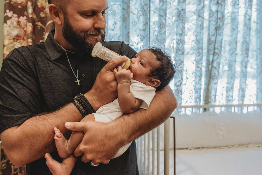 Father bottle-feeds foster son