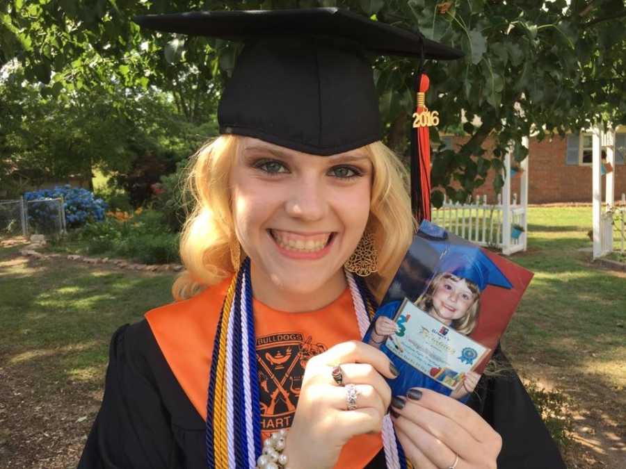 Teen with lupus smiling in cap and gown holding picture of herself as a child wearing cap and gown