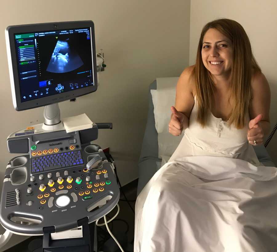 Woman gives a thumbs up while getting an ultrasound done