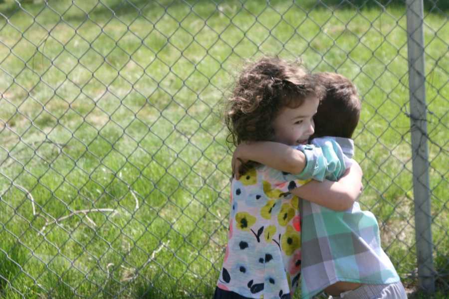 Little girl hugs adopted brother whose parents both passed away