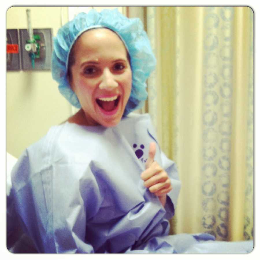 Woman battling infertility gives a thumbs up in the hospital before surgery