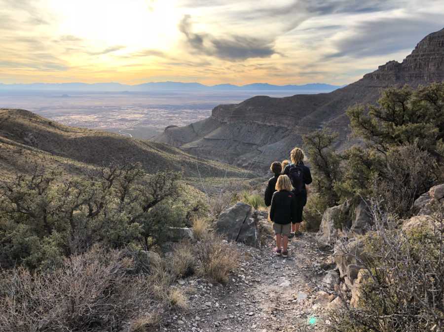 Four children whose family travels the US in airstream walk in line on hike 