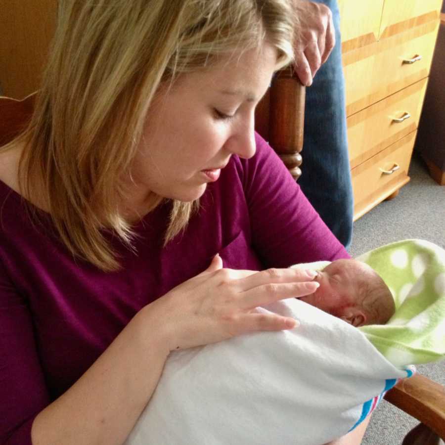 Mother holding newborn swaddled in blanket who won't live long