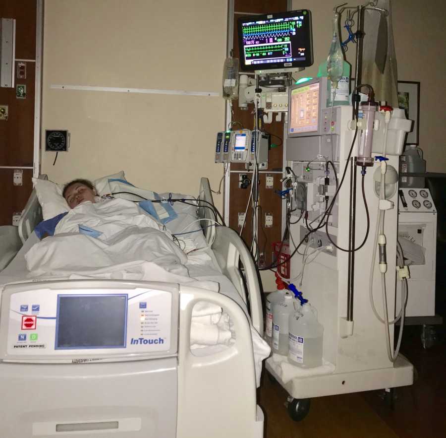 Young woman recovering from a suicide attempt sleeps in the hospital while attached to a lot of wires and machines