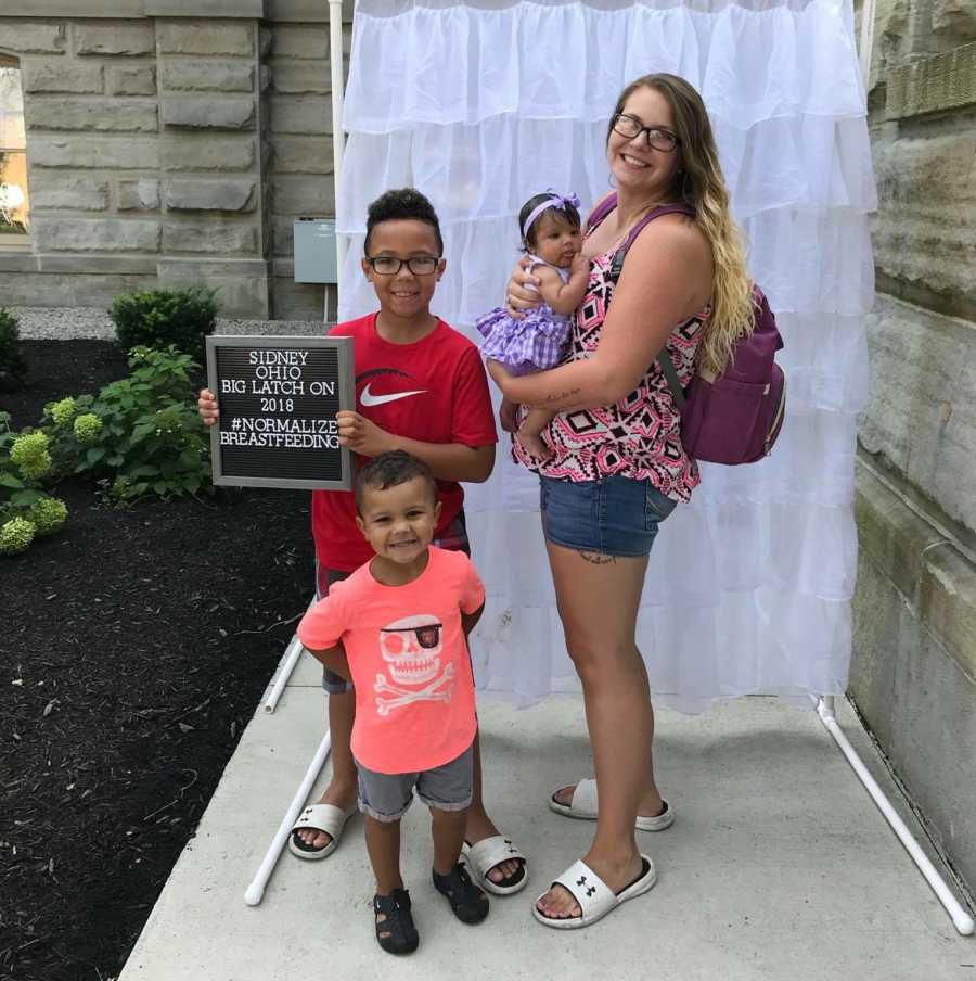 Woman who donates milk to mother stands with her own three children 