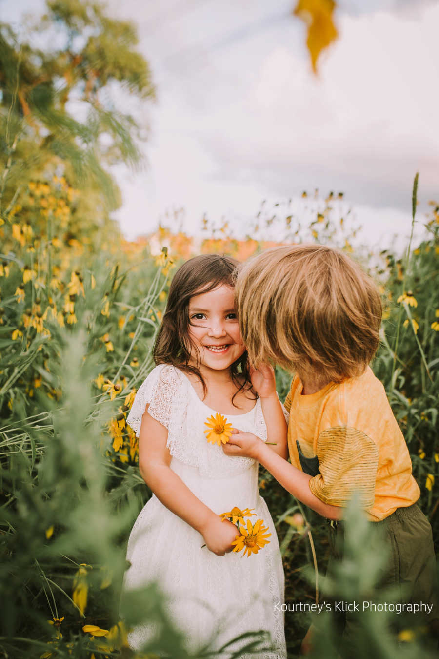 Little girl smiles in sunflower field next to brother with chromosome 7 inversion