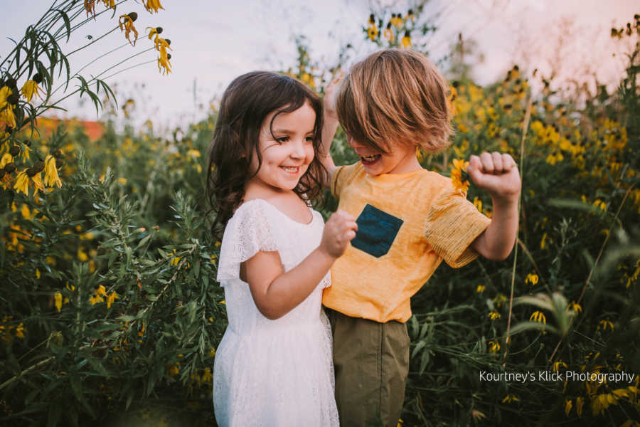 Boy with chromosome 7 inversion and little sister chest bump in sunflower field