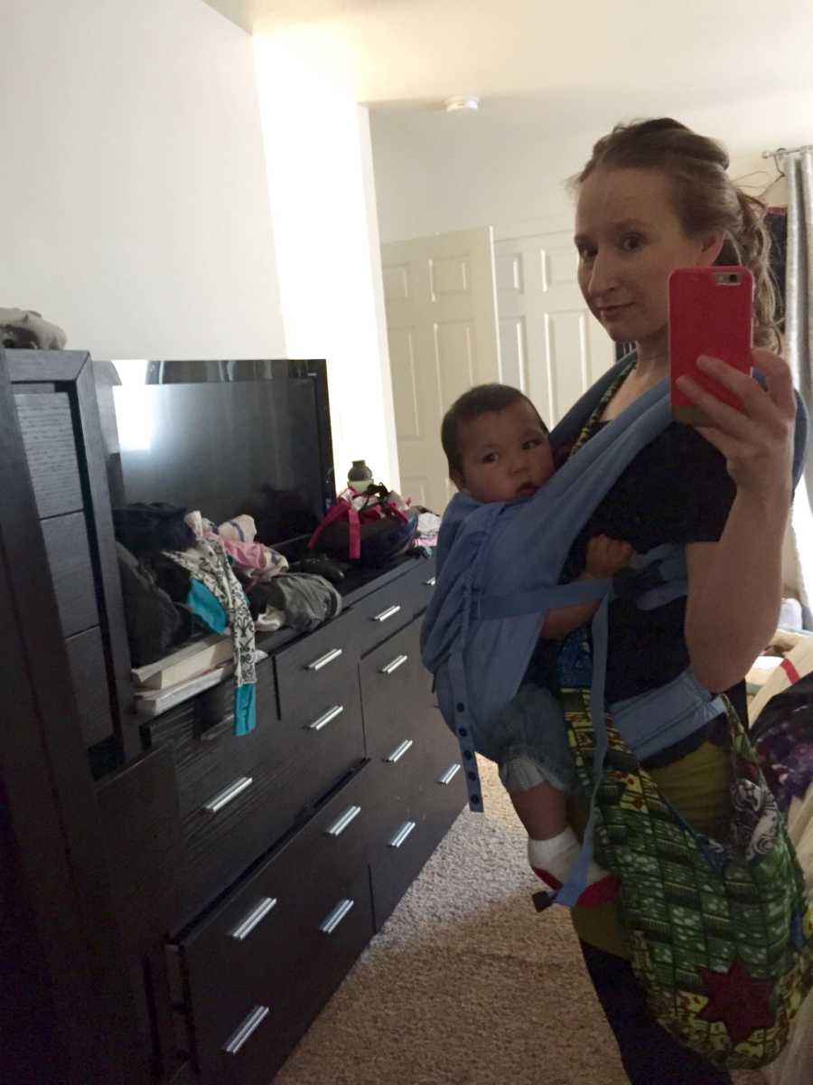 Woman who took in kids to foster takes mirror selfie with baby boy swaddled to her chest