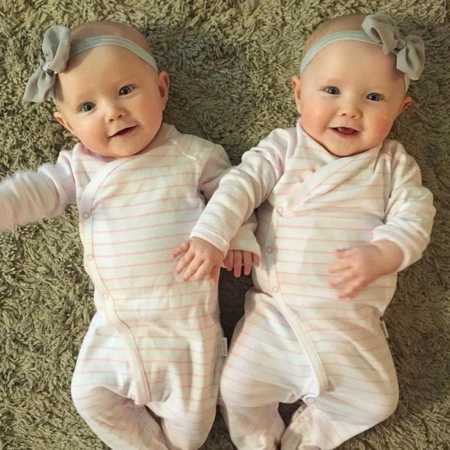 Infant twins who gave mother hard time on plane lying on floor in pink and white striped onesies