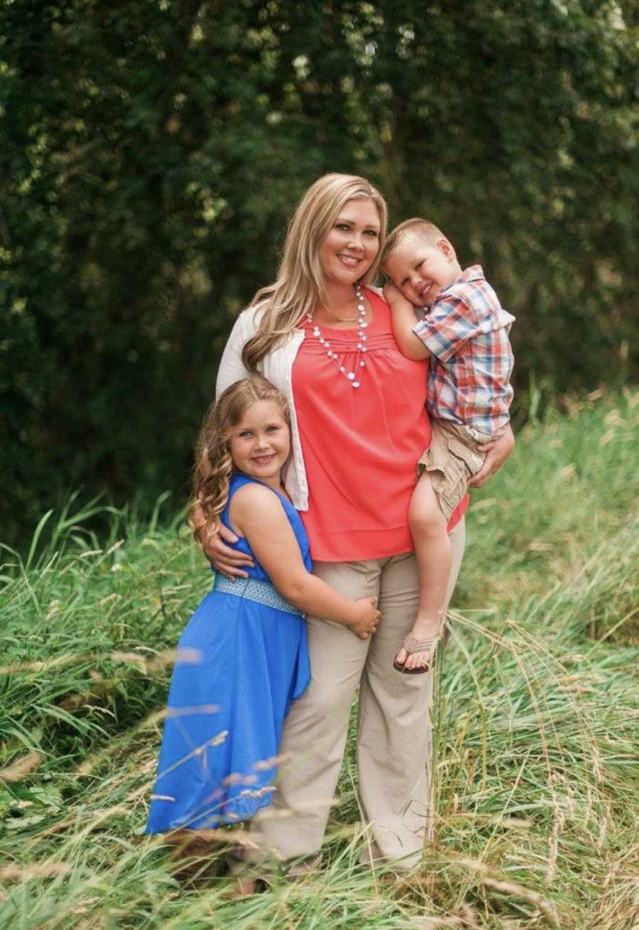 Woman who was a closet drunk stands holding young son with daughter at her side 