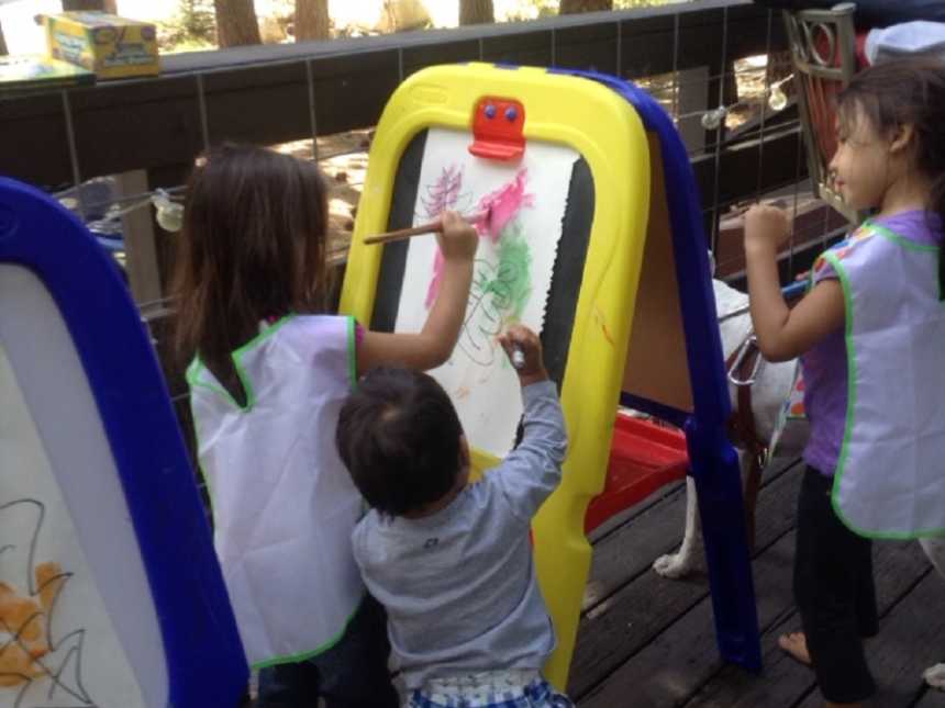 Three foster kids outside painting 