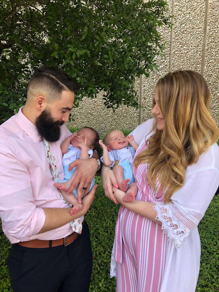 Mother and father hold their twin boys conceived through IVF due to father's lack of sperm
